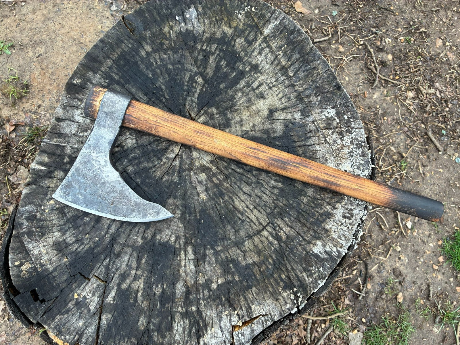 Hand-forged axe on a wood stump
