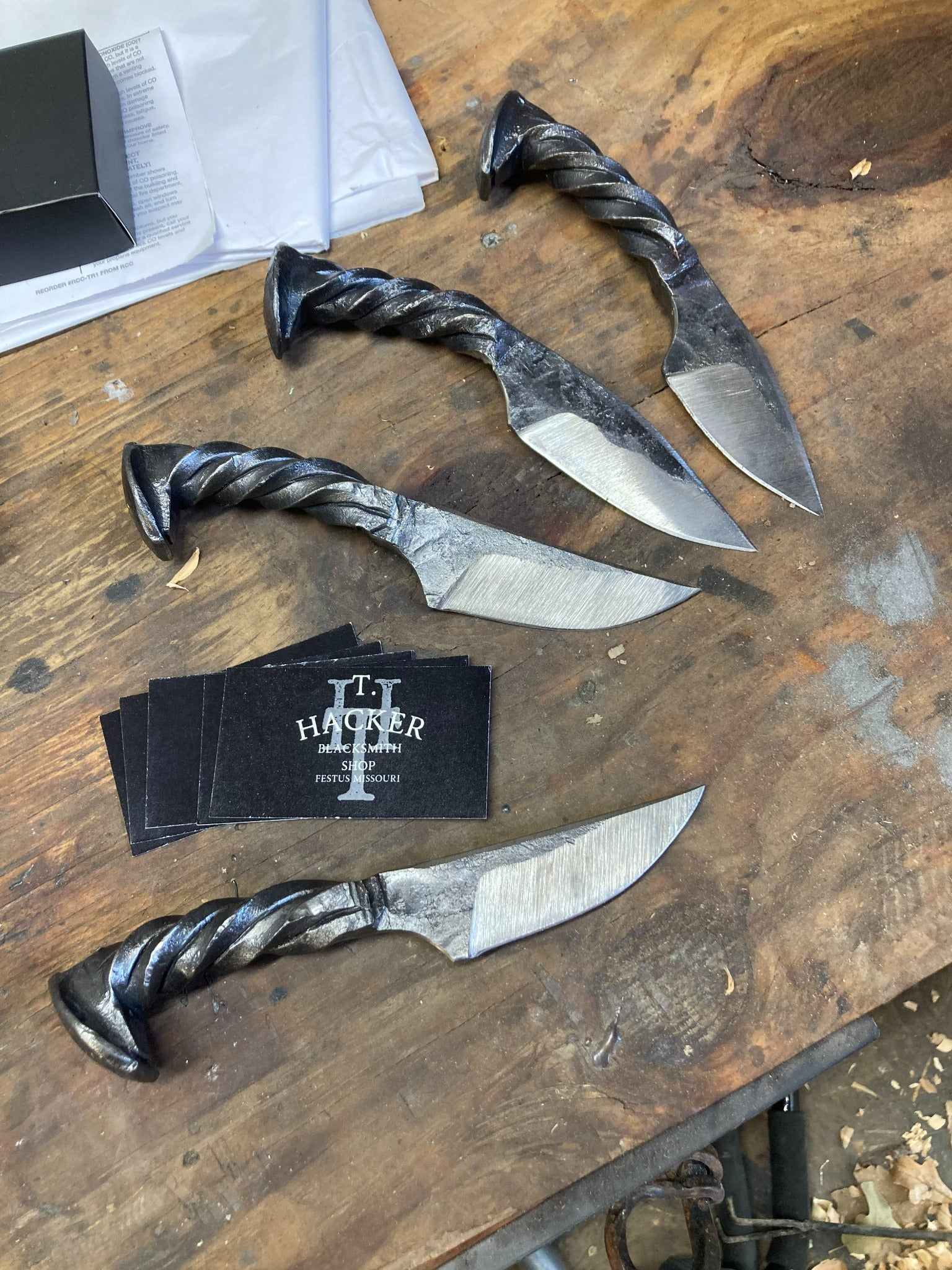 Original photo of hand-forged railroad-spike knives with twisted handles on Thomas's workbench